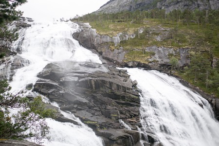 Waterfall in mountains of Norway in rainy weather.の写真素材
