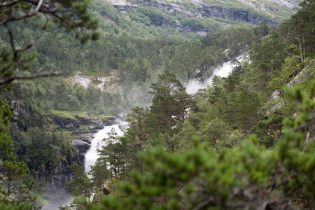 Waterfall in mountains of Norway in rainy weather.の写真素材