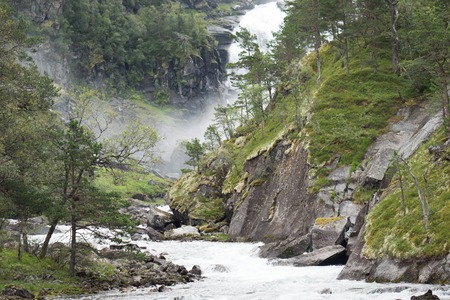 Waterfall in mountains of Norway in rainy weather.の写真素材