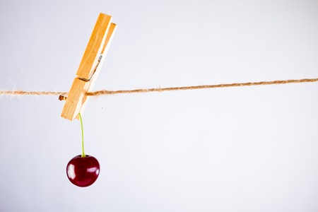 Cherry and rope on white background with clampの写真素材