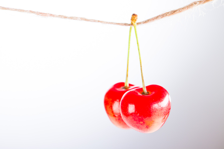Cherry and rope on white background with clampの写真素材