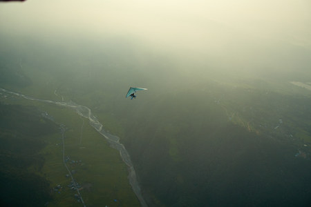 Ultralight aircraft and trees and snowcapped peak at background in the Himalaya mountains, Nepalの写真素材