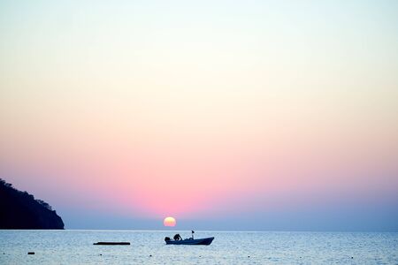 Sunset above sea with boat in Turkeyの写真素材