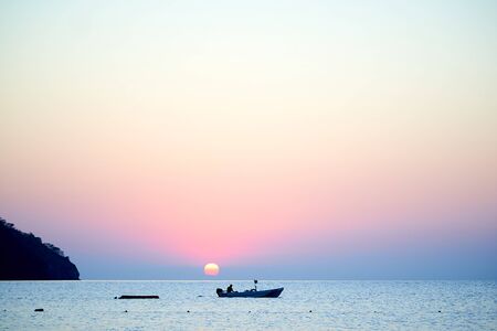 Sunset above sea with boat in Turkeyの写真素材