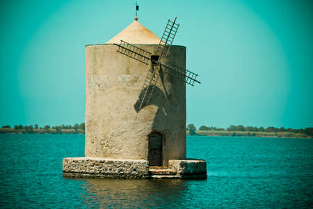 Vintage landscape with windmill on waterの写真素材