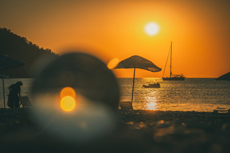Orange sunset above sea with boat amazing Golden reflection of the sun on the calm waves. Summer landscape with sun and sea in Turkeyの写真素材
