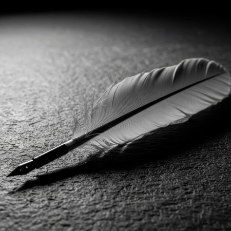 A close-up, dramatic black and white photograph of a quill pen resting on a textured, dark surface, casting a shadow.の素材