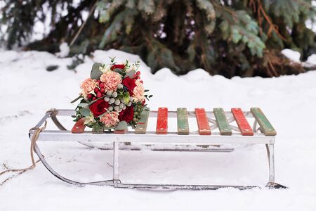 wedding bouquet on old sleds in the winter in the snow near spruceの写真素材