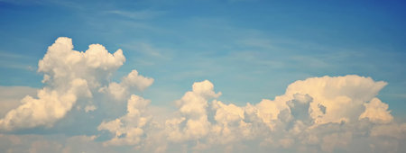 Background with blue sky in which large swirling white clouds