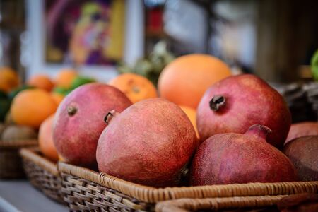 Large, bright, red pomegranatein the wicker basketの写真素材