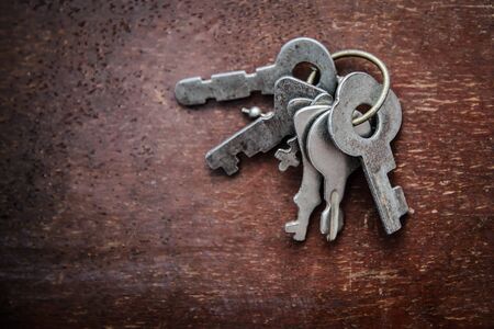 A bunch of the old metal grey small key on old grunge wooden surfaceの写真素材