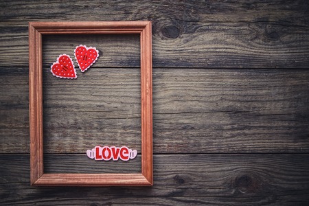 Picture Valentine with a rectangular frame and hearts on wooden backgroundの写真素材
