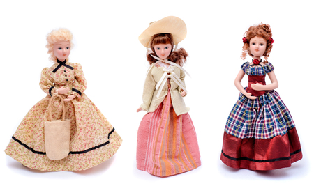 Set of three dolls in vintage dresses with hats, isolate on white backgroundの写真素材