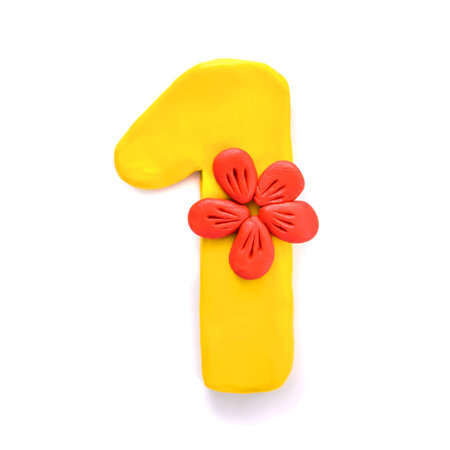 Bright beautiful number one 1 made of yellow plasticine with a red flower, isolate on a white...