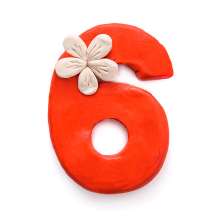 Bright beautiful number six 6 of red plasticine with flower, isolate on a white background