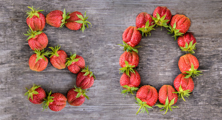 The number 50 of the largest sweet delicious strawberries on wooden backgroundの写真素材