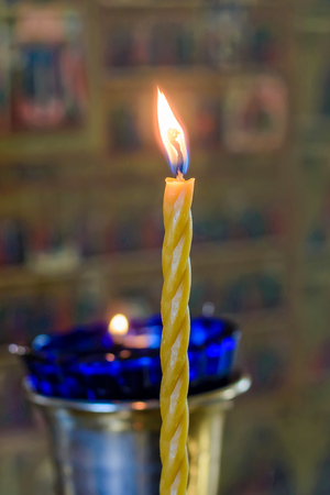 One burning long yellow candle in the Orthodox Churchの写真素材