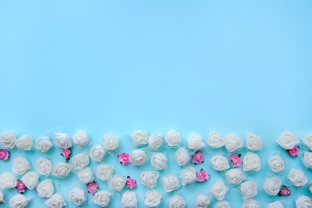 Romantic blue background with small white and pink roses with copy spaceの写真素材