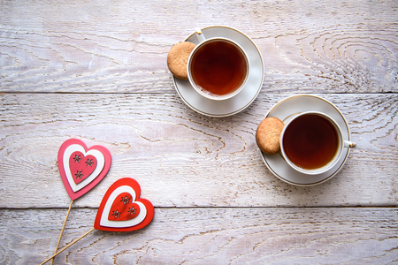 Wooden background with hearts and tea cups on Valentine's dayの写真素材