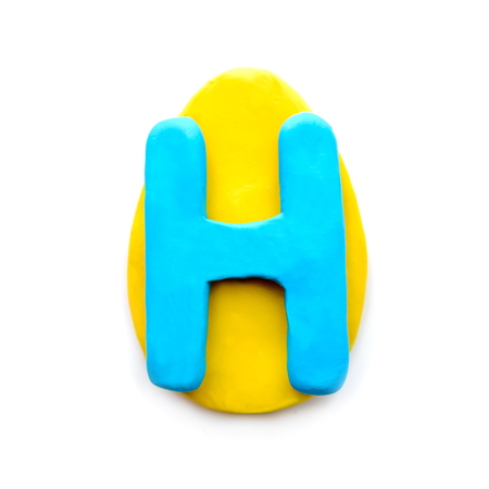 Plasticine letter H in the shape of an Easter egg on a white backgroundの写真素材