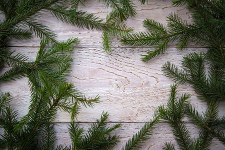 Frame of Christmas tree branches on a wooden background, copy space
