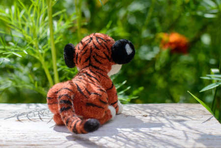 Cute funny little toy handmade woolen tiger, felting from wool, rear viewの写真素材