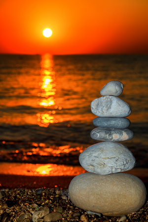 Pyramid of stones on the beach for morning meditation. Beautiful morning sunriseの写真素材