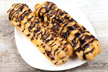 Eclair with custard drizzled with chocolate icing