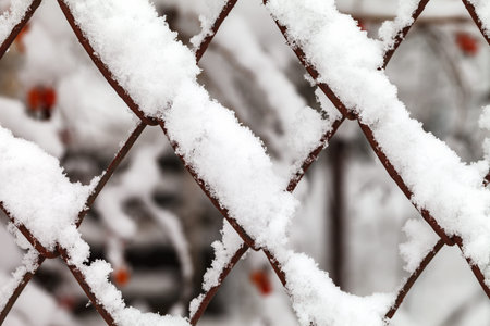 The grid of metal slabs is covered with snow.