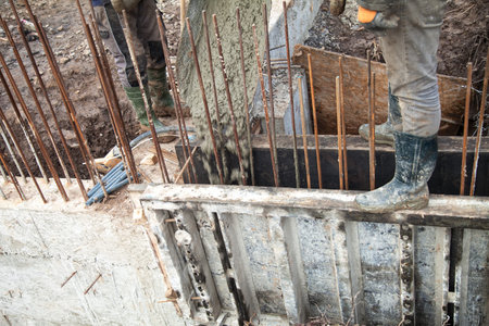 Pouring concrete into the construction of the house