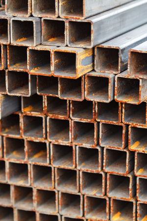 Metal square pipes connected together. The pipes are covered with rust. Outdoor storageの写真素材