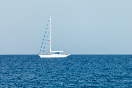 Amazing white sailboat in the mediterranean sea. Blue sky over water horizonの写真素材
