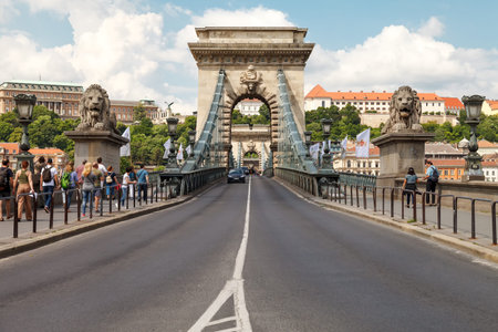 Cars cross the Secheni Chain Bridge in Budapest across the Danube River. Many tourists admire the beauty and grandeur of the architectural structure.のeditorial素材
