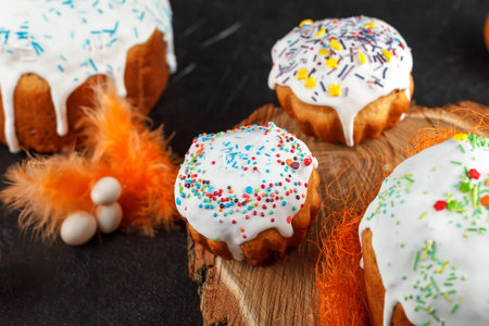 Fresh Easter cake, baked at home and decorated with sweet icing. Colored boiled eggs lie on the...