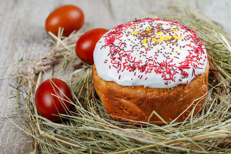 Festive Easter cake on a light background, decorated with multi-colored dragees. Painted Easter eggs...