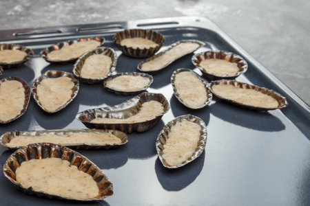 Dough formation. metal shape. Metal molds with dough lie on the pan for further baking in the ovenの写真素材