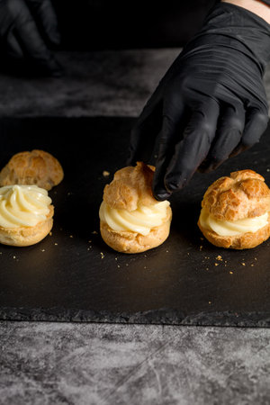 Custard-filled profiteroles ready to serve. The profiteroles are filled with custard and ready to be servedの写真素材