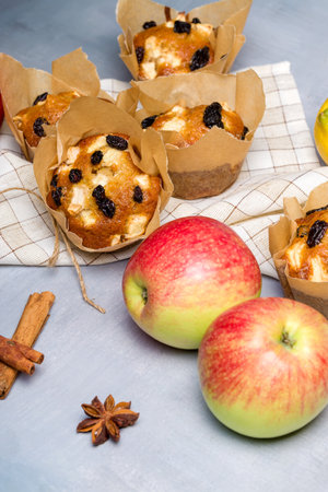 Homemade muffin with apples, raisins and cinnamon sticks. On a light backgroundの写真素材