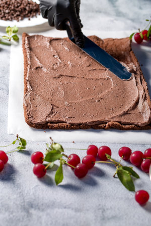The process of making cooking roll in the kitchen with cherries and grated chocolate. home cookingの写真素材