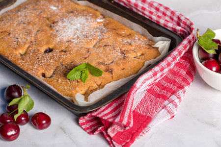 Sponge cake with a cherry on a light background. homemade cookingの写真素材