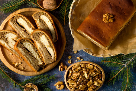Home baked walnut roll. Sliced traditional walnut roll on the background of Christmas tree branches