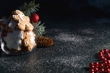 Gingerbread cookies in a transparent glass on a dark background with space for text. Low keyの写真素材