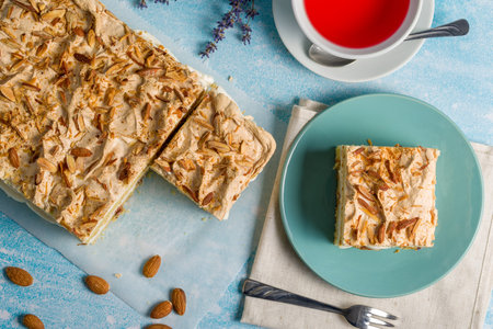 Norwegian cake. With meringue, whipped cream and almonds. Light background.
