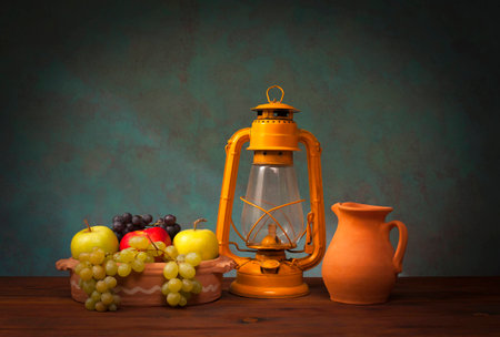 Old lantern and fruits on wooden tableの写真素材