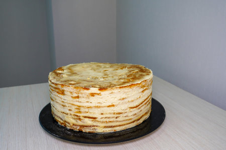 Cook - Confectioner. Cooking a festive multi-layer birthday cake. Scones are smeared with whipped...