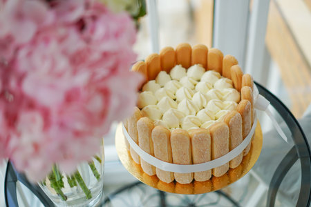Cooking and decorating Tiramisu cake at home by a master. Sponge cake with flowers and cookies