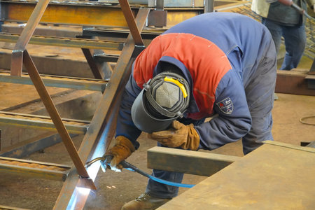 Manual semi-automatic welding. Welder of metal structures for industry. Manual arc welding ..