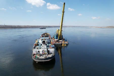 An old motor ship is anchored under sand loadingの写真素材