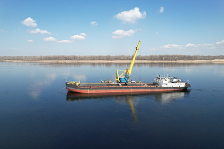 An old dry-cargo ship is anchored under sand loading on the Volga