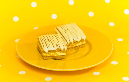 banana cake on an orange dish on a white polka dot yellow backgroundの写真素材
